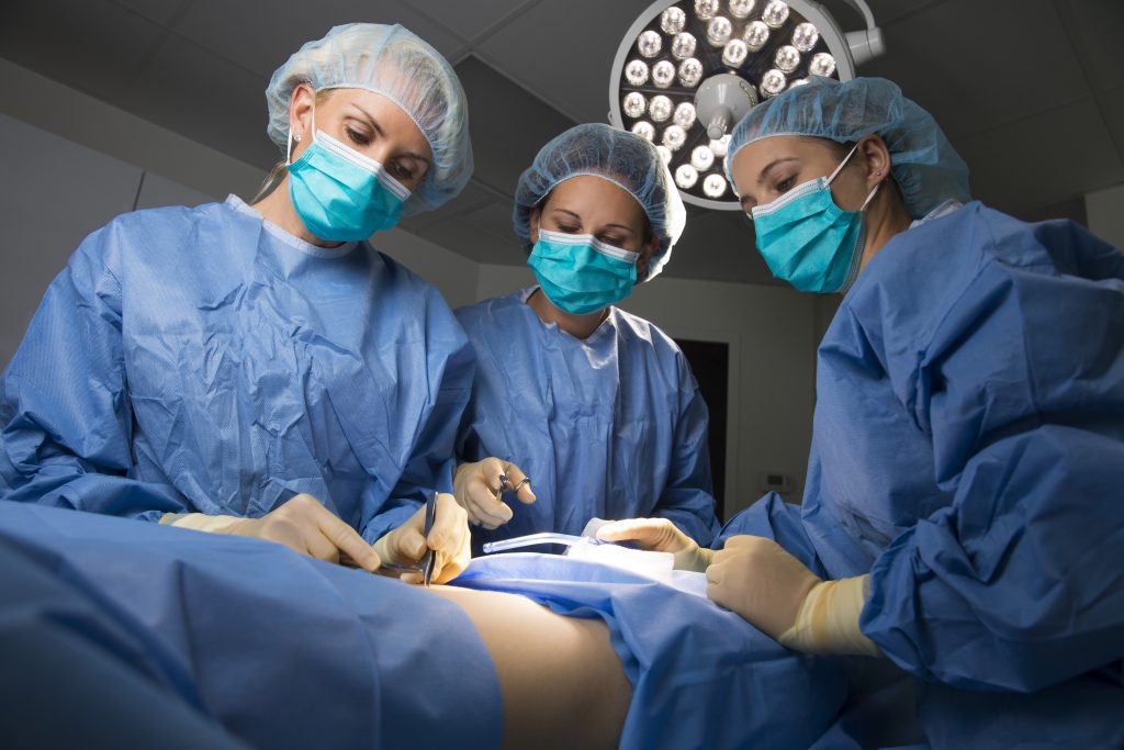 three surgeons performing surgery in an operating room