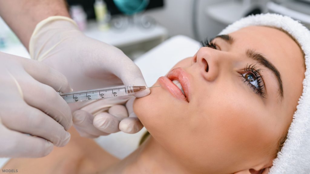 Woman receiving injectable treatment (models)